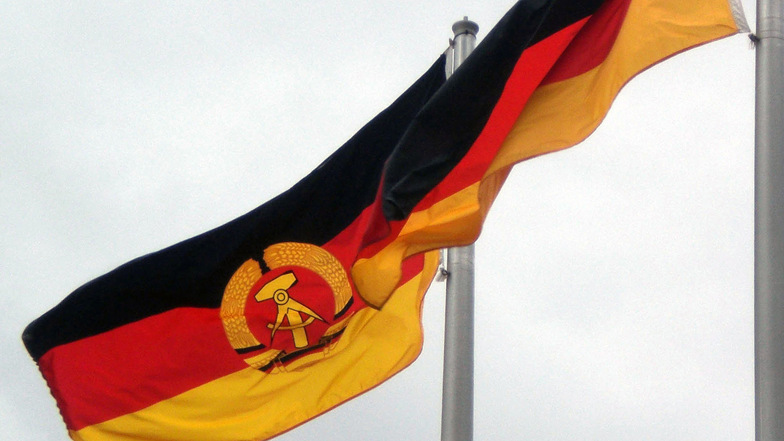 Die Flagge der ehemaligen DDR und die bundesdeutsche Fahne: Wie sehr wirkt sich das Erbe der DDR auf die heutige Gesellschaft aus? Darum geht es beim 31. Bautzen-Forum.