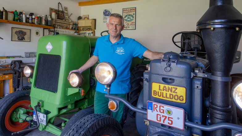 Traktorfan Ronny Pietzsch steht zwischen seinen liebevoll restaurierten Treckern: links ein Aktivist und rechts ein Lanz Bulldog.