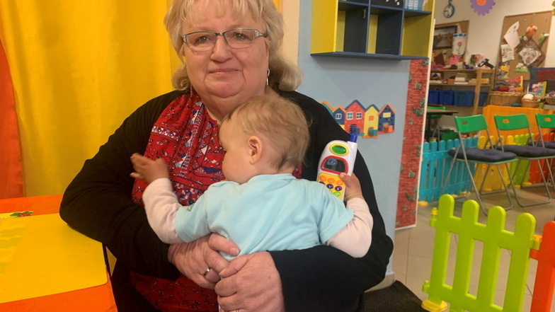 Die Großenhainer Tagesmutter Ines Neubert hält die kleine Kimberly im Arm."Wir betreuen individueller", sagt die 61-Jährige.