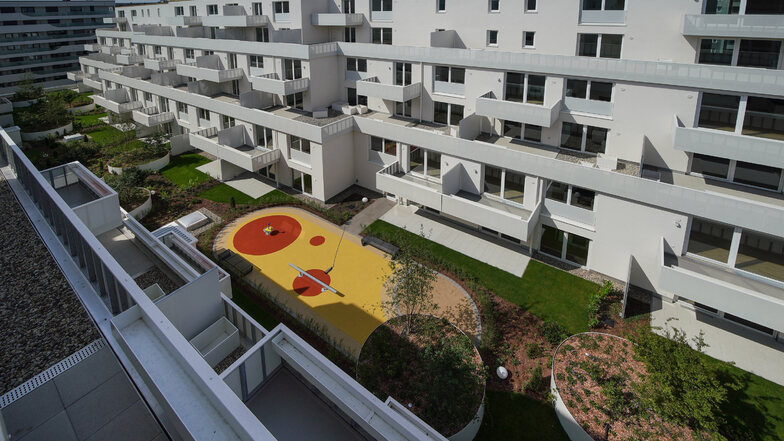 Terrassenförmig abgestuft sind die beiden Neubauten am Hof. Er befindet sich in Höhe des zweiten Stocks, ist bepflanzt und hat einen Spielplatz.