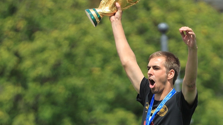 Philipp Lahm jubelt am 15.07.2014 beim Empfang der Fußball-Nationalmannschaft in Berlin mit dem WM-Pokal.