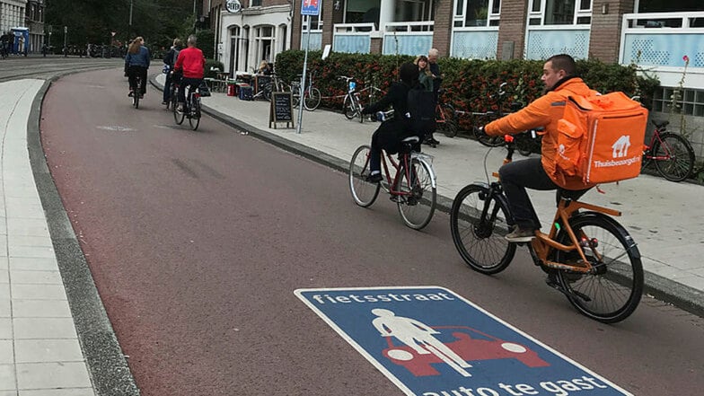 Radfahrer sind in Amsterdam auf einer "Fietsstraat" unterwegs, einer Straße für Radfahrer, auf der Autos nur zu Gast sind. Fiets heißt Fahrrad.