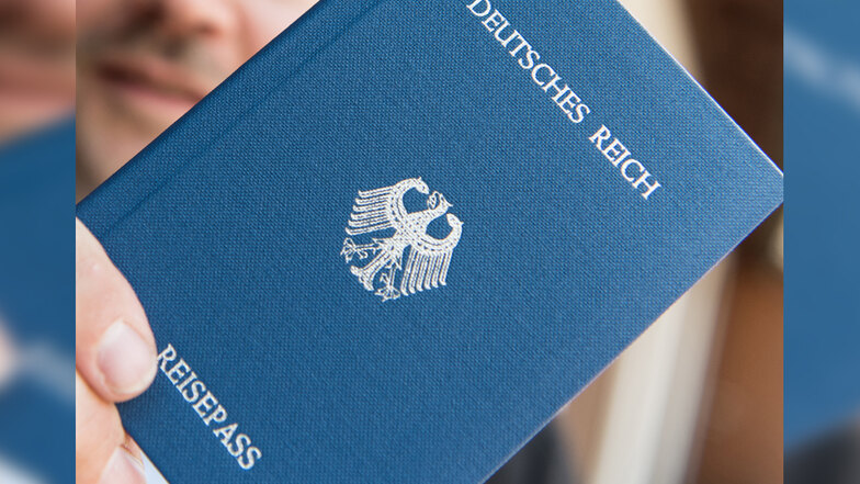Ein Mann hält ein Heft mit dem Aufdruck «Deutsches Reich Reisepass» in der Hand, dass bei "Reichbürgern" als Dokument anerkannt ist.