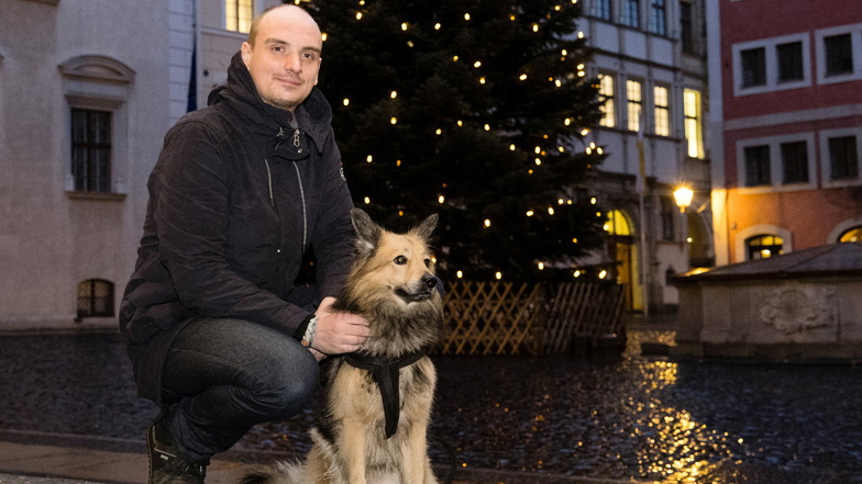 Stefan Hoffmann mit seinem Hund Rudi vor dem von ihm ersteigerten Weihnachtsbaum auf dem Untermarkt in Görlitz.