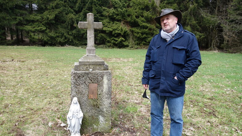 Wochenendhäusler Jaroslav Cervík steht am Kreuz, das der Bergverein für die ehemaligen Bewohner von Adolfov (Adolfsgrün) anstelle des ehemaligen Friedhofs errichten ließ.