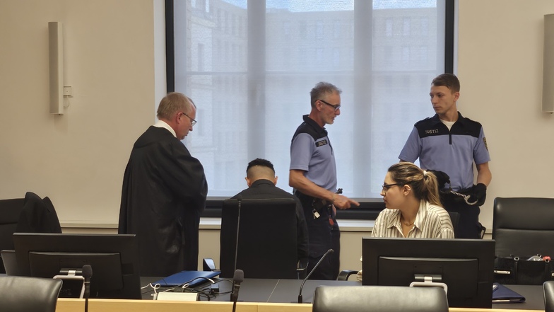 Prozessauftakt im Landgericht Dresden: Zwei Wachtmeister haben den Angeklagten Kais M. (2. v. r. mit seinem Verteidiger Ulf Israel, r.) von seinen Handschellen befreit.