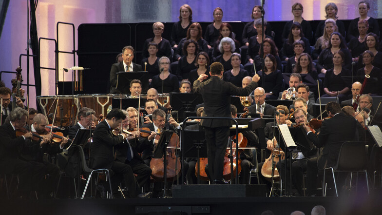 Die Berliner Philharmoniker unter der Leitung des Chefdirigenten Kirill Petrenko (M) spielen ein Konzert am Brandenburger Tor. So nah beieinander sitzen können die Musiker in Corona-Zeiten nicht mehr.