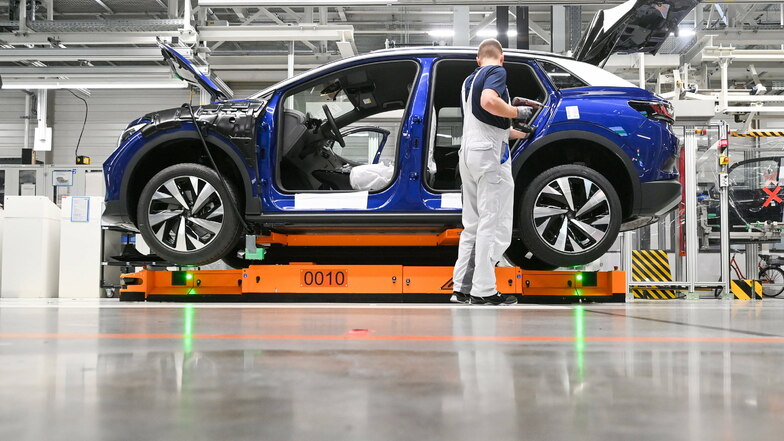 Ein Mitarbeiter im Volkswagenwerk in Zwickau komplettiert einen VW ID.4. Volkswagen produziert im Werk in Zwickau das erste reine Elektro-SUV.
