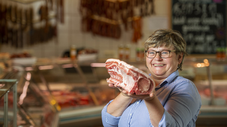 Andrea Franke mit einem Schweinekotelett in der Weinböhlaer Fleischerei: Sie ist Sachsens einzige Wurst-Sommelière. Nun will sie sich auch noch zur Schinken-Expertin ausbilden lassen.