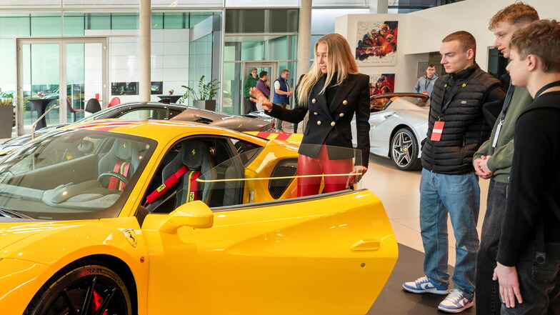 Nicht nur in Rot, auch in Gelb gibt es Ferrari-Sportwagen im Radebeuler Autohaus.  Geschäftsführerin Sibylle Thomas-Göbelbecker erklärt Lino, Eric und Finn (v. l. n. r.) die Technik und Funktionsweise des schnittigen Flitzers.