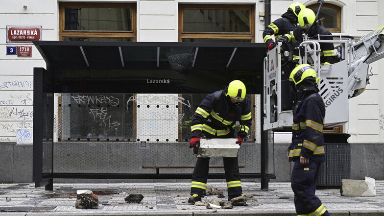 Feuerwehrleute arbeiten an der Stelle, an der ein Mann starb, als er von einem Fassadenteil getroffen wurde, das von einem Dach an einer Straßenbahnhaltestelle in der Lazarská-Straße fiel