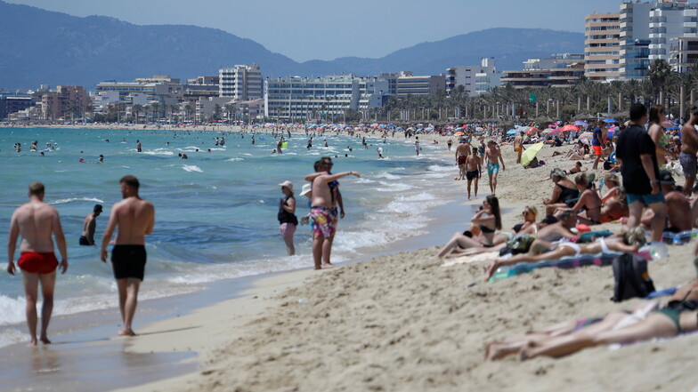 Touristen halten sich am Strand von Arenal in Palma de Mallorca auf. Nun hat das RKI Spanien zum Hochrisikogebiet erklärt.