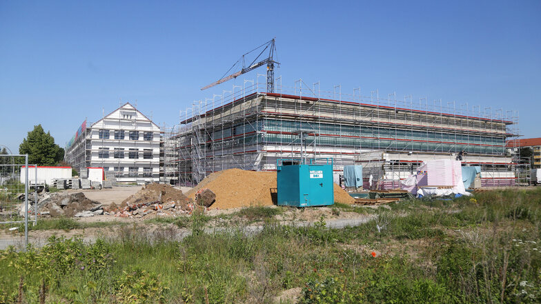 Blick auf die neue Turnhalle (rechts) und das frisch gemalerte und entkernte Haupthaus (l.) der Schule Am Merzdorfer Park. Seit Anfang 2019 laufen die Arbeiten.