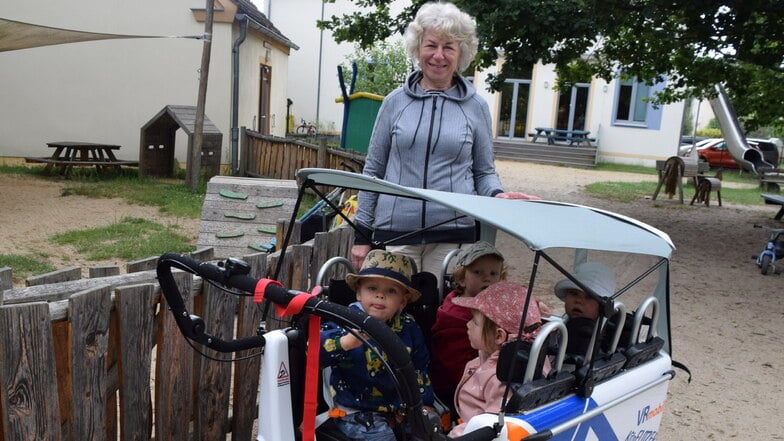 So sehen die Wagen aus, die die Genossenschaftsbank an Kitas im Kreis Görlitz verschenkt. Petra Bauz, die Leiterin der Kita Meuselwitz, ist gern mit den Jüngsten im Wagen unterwegs.