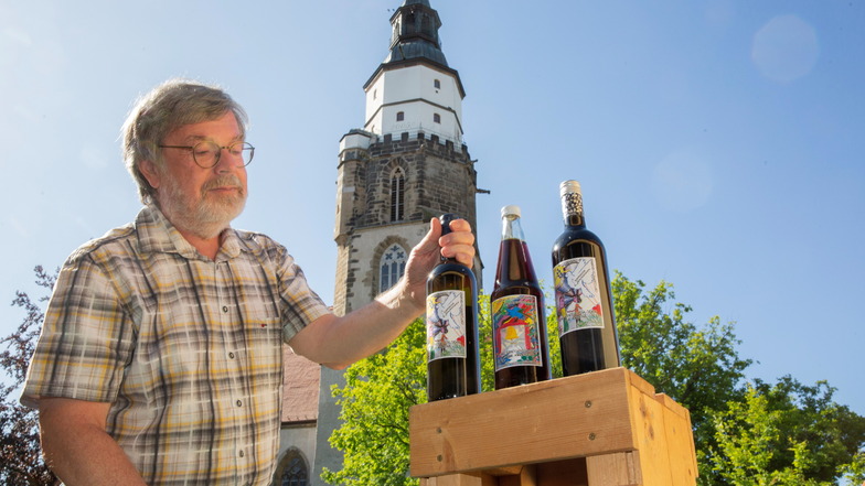 Thomas Hein zeigt Wein und Traubensaft, mit denen der Guss einer Friedensglocke für die Kamenzer Kirche St. Marien unterstützt werden soll. Die Flaschen gibt es gegen eine Spende.