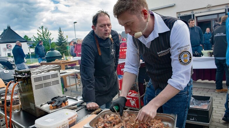 Fleischsommelier Ronny Paulusch aus Wien (oben li.) schaut Christoph Schempp aufmerksam über die Schultern, wie er mit der Bärenkralle das Pulled Pork auseinanderzieht.