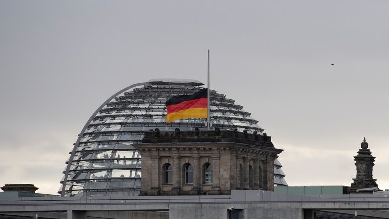 31.12.2022: Die Deutschland-Fahnen auf dem Dach des Reichstagsgebäudes wehen auf Halbmast, nachdem der Tod des emeritierten Papstes Benedikt XVI. bekannt geworden war.