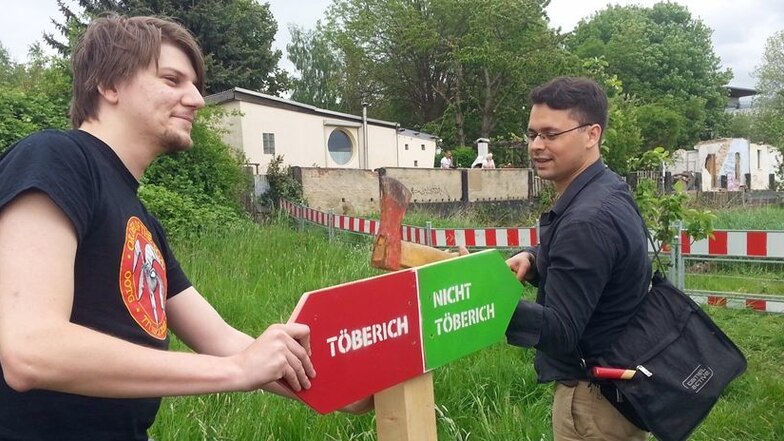 Dieses Schild greift Regine Töberichs „Baggerfehler“ humorvoll auf. Sebastian Hähnel (l.) und Johann Koenitz gehören eigener Aussage zufolge der Bewegung „Echte Demokratie Jetzt!“ an.