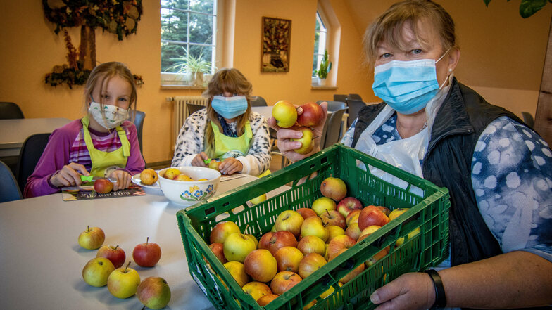 Fürs Foto helfen die Viertklässlerinnen Friederike und Johanna (beide 10) Andrea Pampel beim Obstschneiden. Die technische Mitarbeiterin der Grundschule Sitten bereitet die Obstteller sonst allein zu – coronabedingt.