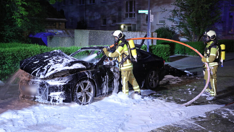 Ein Audi steht auf der Feldgasse in Dresden-Altstadt in Flammen und wird von der Feuerwehr gelöscht.