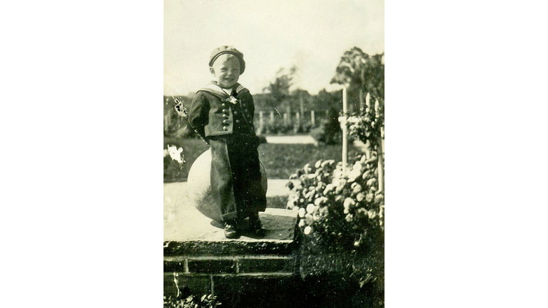Manfred Kapplick im Alter von drei Jahren mit Marineanzug vor einer Kugel des Reinhardtsthales in Hartha.