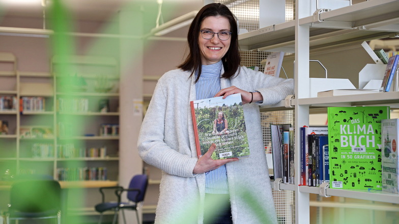 Die Riesaer Bibliotheksleiterin Susan Bazylak zeigt eines der ersten Bücher der neuen "Grünen Bibliothek".