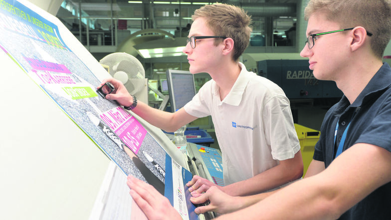 Christian Vogel (links) und Tom Cedric Gottschlich lernen beim Druckereibetrieb United Print in Radebeul. Wie viele andere Firmen sucht das Unternehmen nach neuen Azubis.
