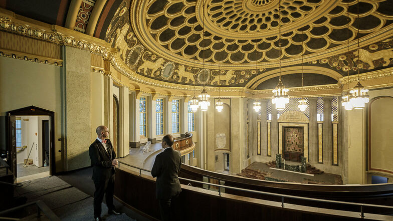 Sparkassenvorstand Michael Bräuer (links) und Oberbürgermeister Octavian Ursu stehen in der ehemaligen Synagoge und schauen sich die neuen Leuchter an.