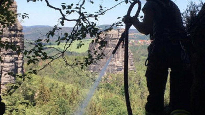 An Seilen gesichert löschten Feuerwehrleute aus Ottendorf die Flammen an der Schrammsteinkette.