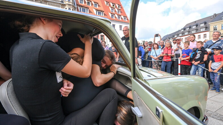 Bei einem Rekordversuch auf dem Zwickauer Hauptmarkt zwängen sich im September 2021 20 junge Sportlerinnen in einen Trabant 601.