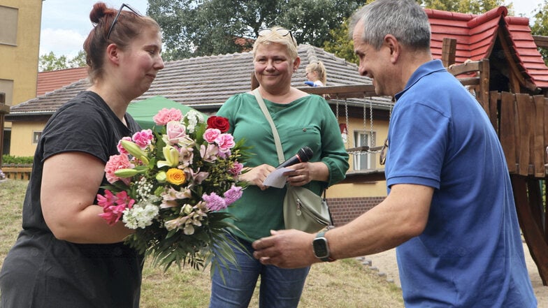 Erzieherin Lea Krautz verlässt die Kita. Mit einem großen Blumenstrauß bedankten sich ihre Chefin Michaela Rakow und Bürgermeister Jörg Funda (v.li.).