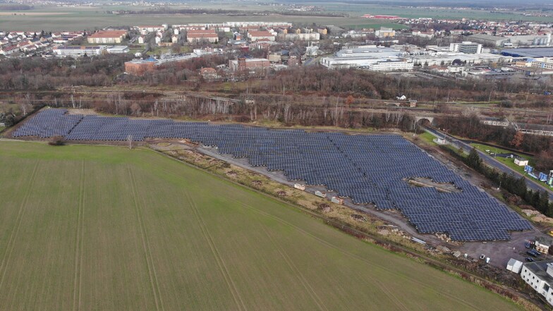 Das Luftbild zeigt das Ausmaß des Solarkraftwerks. Rechts verläuft die Rostocker Straße, im Hintergrund die Bahnlinie Dresden-Leipzig.
