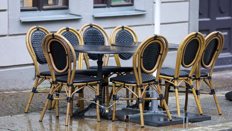 Leere Stühle stehen bei Regen vor einem Restaurant in der Leipziger Innenstadt: In vielen Gastro-Betrieben liegt der Umsatz noch immer unter dem der Vor-Corona-Jahre.