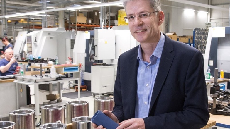 Der geschäftsführende Gesellschafter der PTFE Competence Center GmbH Andreas Madaus erklärt in der Produktionshalle des Unternehmens an einem Stück PTFE-Halbzeug-Rohr die Verarbeitung des Kunststoffs.