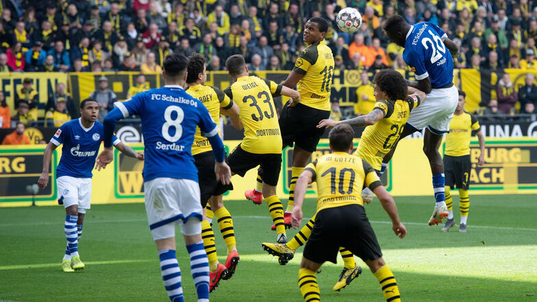 Mit diesem wuchtigen Kopfball bringt Salif Sane (r.) die Schalker mit 1:2 in Führung. Dortmund reagiert genervt, fängt sich zwei Rote Karten ein.