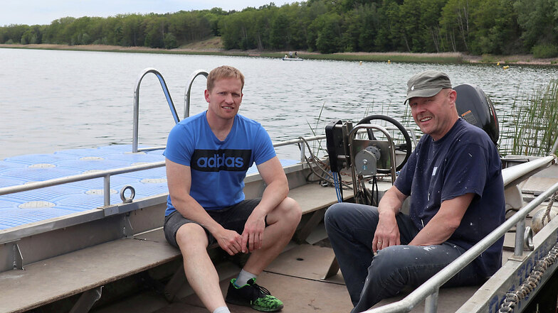 Marcel Fechner (links), der Leiter der Kanu-Kids Lohsa, und Uwe Schneider, der Vorsitzende des Wassersportvereins „Am Blauen Wunder“ Dresden, verweilen unweit der künftigen Regatta-Strecke auf dem Dreiweiberner See.