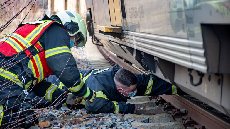 Döbelner Feuerwehrleute inspizieren den Schaden am Treibstofftank eines Personenzuges, der im Döbelner Hauptbahnhof liegengeblieben ist.