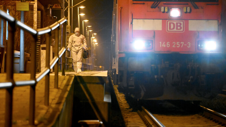 Mitarbeiter der Spurensicherung sind auf einem Bahnsteig neben dem Regionalzug im Bahnhof im Einsatz.