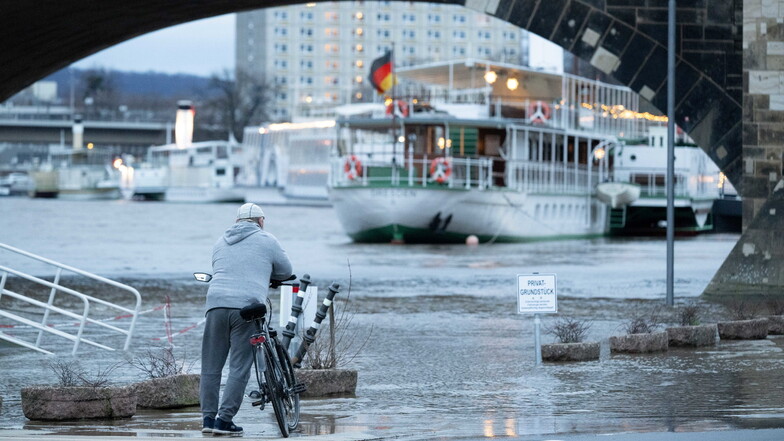 Ein Passant steht am Terrassenufer an der Elbe. Die Hochwasserlage hat sich in Teilen Sachsens verschärft.