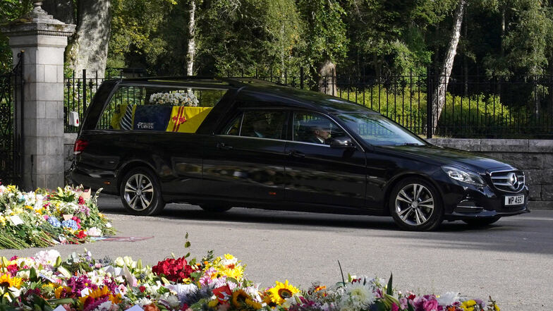 Der Leichenwagen mit dem Sarg von Königin Elizabeth II., der mit der königlichen Standarte von Schottland behängt ist, verlässt Schloss Balmoral und beginnt seine Fahrt nach Edinburgh.