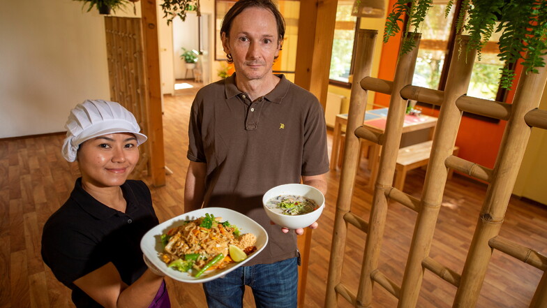 Ratchanee Kotte und ihr Ehemann Oliver Kotte präsentieren zur Eröffnung des Baan Thai Bistros in Pirna eine Curry-Suppe Tom Kha Gai (r.) und gebratene Reisbandnudeln nach Thai Art.