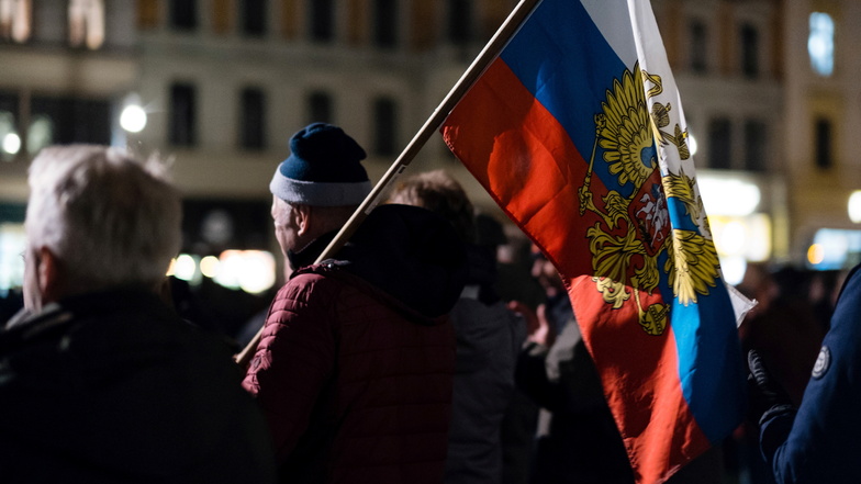 Teilnehmer der Montagsdemo tragen die Russlandfahne mit dem Zaren-Wappen auf dem Görlitzer Postplatz.