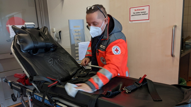 Nachbereitung: Christopher Neidhardt reinigt die Patientenliege, bevor er sie zurück in den Rettungswagen schiebt.