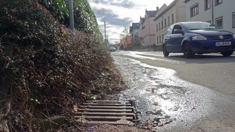 Wasser tritt aus der Hauptstraße in Limmritz aus und verschwindet in einem Einlauf. Ist es ein Wasserrohrbruch?