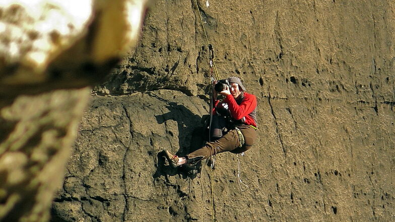 Mike Jäger als Bergsportfotograf in der Sächsischen Schweiz. Hier hängt er an der Wildensteinwand, um Kletterer an der gegenüberliegenden Zyklopenmauer zu fotografieren.
