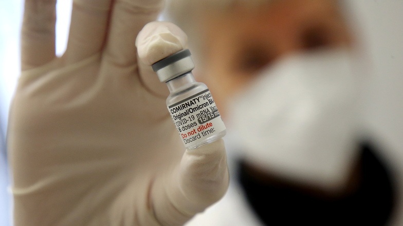 Eine Ärztin zeigt eine Flasche mit dem neuen Corona-Booster von Biontech. Aktuell wird der an BA.4/5 angepasste Impfstoff verimpft. Die Sächsische Impfkommission empfiehlt die vierte Impfung für bestimmte Personengruppen, wie ältere oder Risikopatienten.