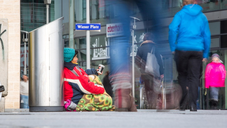 Eine Frau auf dem Wiener Platz in Dresden bittet um Geld.