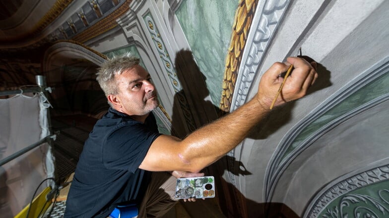 Mit dem feinen Pinsel bemalt Markus Pinther die letzten Stellen an der Kuppel der Kreuzkapelle.