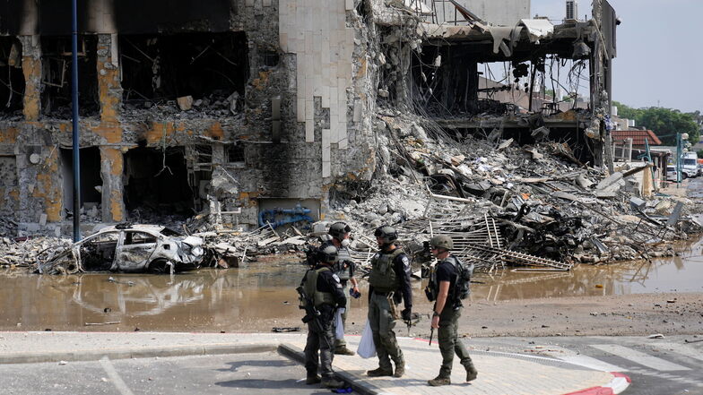 Israelische Polizisten stehen vor einer zerstörten Polizeistation.