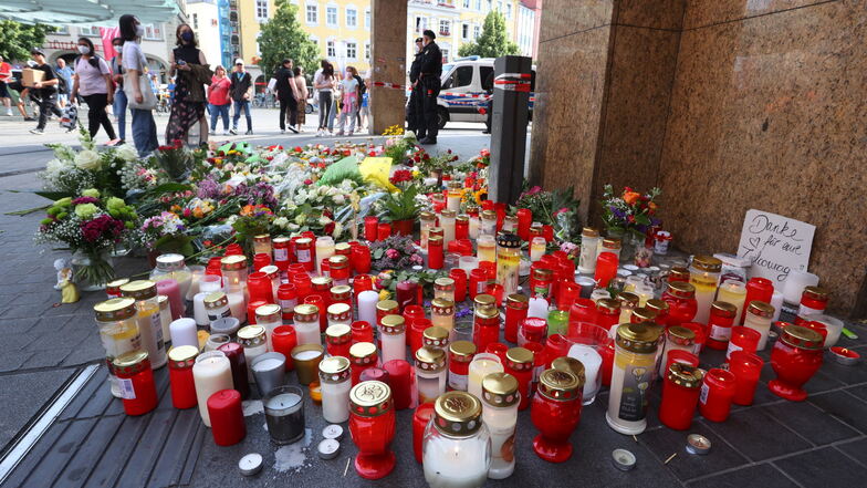 Blumen und Kerzen stehen vor dem geschlossenen Woolworth-Kaufhaus in der Innenstadt von Würzburg. HIer hatte ein Mann am Freitag wahllos Menschen mit einem Messer angegriffen.